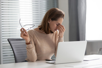 Fatigued stressed young businesswoman secretary feel eye strain at work