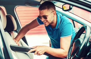 Obraz premium Man cleaning the interior of his car. Car care concept