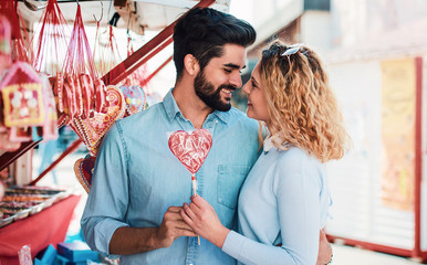 Happy couple buying candies on the street market. Love, dating, romance, shopping