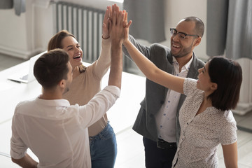 Happy motivated diverse business team people giving high five together