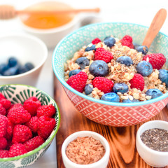 High protein healthy breakfast, buckwheat porridge with blueberries, raspberries, flax seeds and honey Closeup view, selective focus