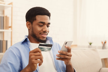 Man holding credit card and using smartphone for online shopping