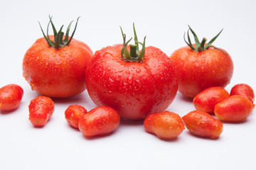 Tomates maduros y tomates cherry juntos en la misma foto. Foto de conjunto de tomates saludables y sanos, hay tomates grandes y tomates cherry