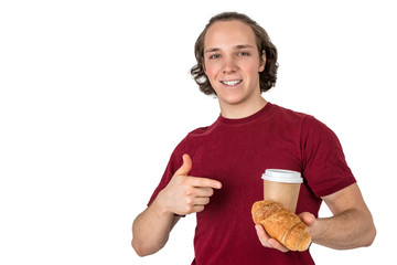 Young handsome man drink coffee and eating croissant. French breakfast and morning coffee. Isolated