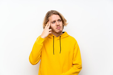 Blonde man with  sweatshirt over white wall with problems making suicide gesture
