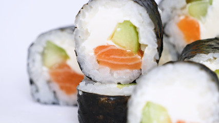 Close-up of professional chef's hands in transparent gloves making sushi and rolls in a restaurant kitchen. Japanese traditional food. Preparation process. Concept of: Preparing, Rolling, Salamon.