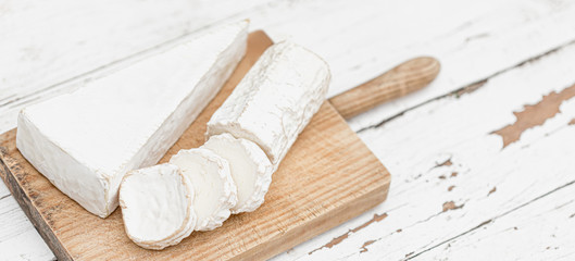 Wooden board with various cheese on white background. Cheese platter. Copy space