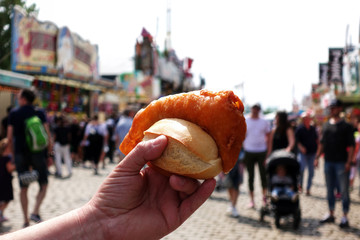 Traditional fish in hand. Mobile food truck selling freshly hand buttered cod fish outdoors. Fish at amusement park or street food festival