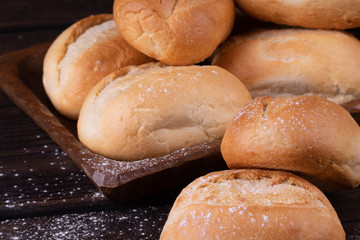 Buns in bread basket on a wooden background, low key