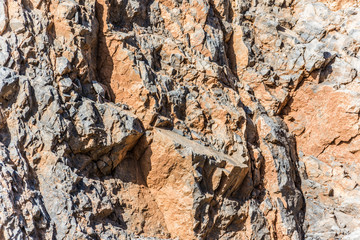 background and texture of mountain layers and cracks in sedimentary rock on cliff face. Cliff of rock mountain.