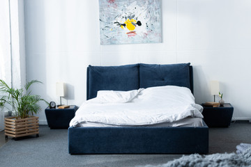 cozy modern bedroom with bed and green plant