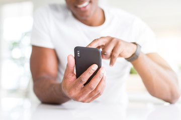 Close up of african american man hands using smartphone and smiling