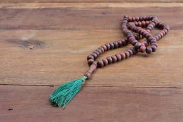 close up of wood tasbih with blur bokeh on wooden background. Wooden rosary
