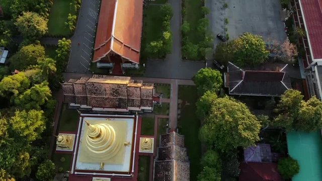 birdeye aerial over wat phra singh to tilt up to sunrise over old city