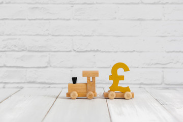 Golden pound sign on wood train over white background with copy space