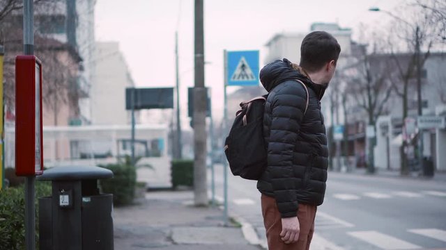 Man is standing near road with pedestrian crossing
