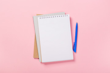school notebook on a pink background, spiral notepad on a table.