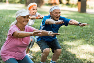 Obraz premium selective focus of retired man doing sit ups with senior women