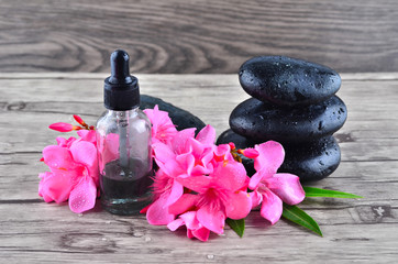 Essence oil and flower with zen stone on wood background