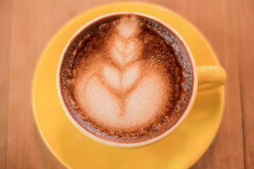 coffee latte art in the yellow coffee cup