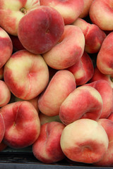 Fototapeta na wymiar Flat peaches sale in market. Harvest