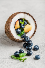 Fresh blueberries and peaches with mint bowl of coconut