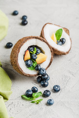 Fresh blueberries and peaches with mint bowl of coconut