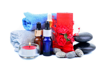 Obraz na płótnie Canvas Red romantic candle and spa oil with towel and zen stone isolated on white background