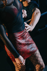 cropped view of client touching seductive prostitute in red skirt standing near car