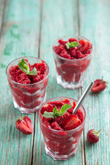 strawberry sorbet ice cream in a glass, green wooden background