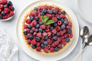 blueberry  and raspberry tart  on white marble background
