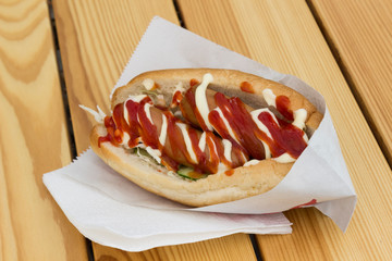 Fast food concept: hot dog with two sausages and ketchup on the table. Top view