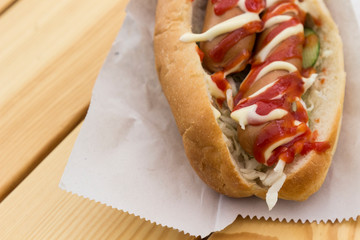 Fast food concept: hot dog with two sausages and ketchup on the table. Top view