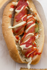 Fast food concept: hot dog with two sausages and ketchup on the table. Top view