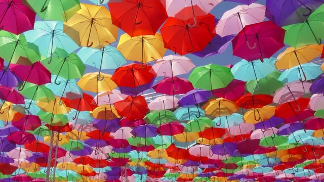 Top view of street decorated with multicolored umbrellas in Aix en Provence, France. Beautiful colorful parasols hanging in air above at sunny summer day