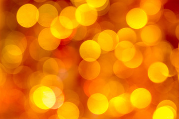 Obraz premium Festive red blurry background with yellow and orange bokeh_