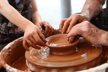 Master of ceramics. We work with clay. The master ceramist teaches the student. Craftsman hands...