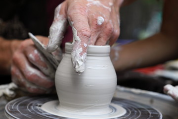 Master of ceramics. We work with clay. The master ceramist teaches the student. Craftsman hands sculpts clay
