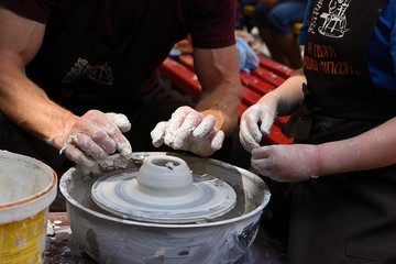 Master of ceramics. We work with clay. The master ceramist teaches the student. Craftsman hands sculpts clay