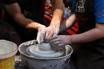 Master of ceramics. We work with clay. The master ceramist teaches the student. Craftsman hands sculpts clay
