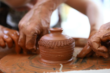 Fototapeta na wymiar Master of ceramics. We work with clay. The master ceramist teaches the student. Craftsman hands sculpts clay