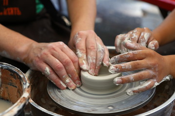 Master of ceramics. We work with clay. The master ceramist teaches the student. Craftsman hands sculpts clay
