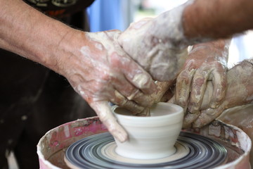 Master of ceramics. We work with clay. The master ceramist teaches the student. Craftsman hands sculpts clay