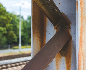 rusty metal pole near railway tracks