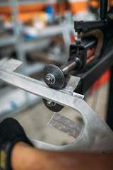 Worker bending metal part indoor workshop, close-up. old school metal shaping 