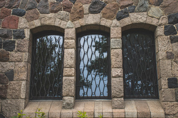 three vintage Windows in a stone wall
