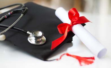 Black graduation cap, degree and stethoscope