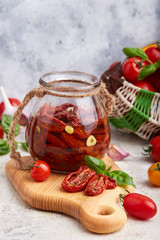 Sun dried tomatoes with herbs, garlic and olive oil in jar. Vegetarian food.