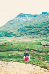 Hiker enjoying a gorgeous view of mountains and waterfalls in Iceland. Travel / vacation concept. Outdoor shot.