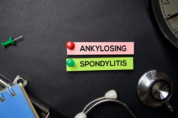 Ankylosing Spondylitis text on Sticky Notes. Top view isolated on black background....